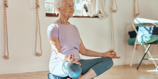 femme-agee-yoga-meditation-et-bien-etre-assise-sur-le-sol-dans-une-salle-de-sport-ou-un-club-de-fitness-1536x1039_main