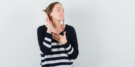 young-woman-standing-listening-pose-holding-one-hand-chest-while-closing-eyes-striped-knitwear-black-pants-looking-happy-2-_main