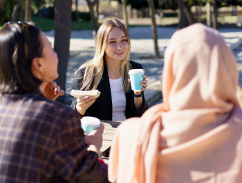 three-diverse-girls-having-coffee-break-and-chatti-2023-11-27-05-09-41-utc-scaled_main