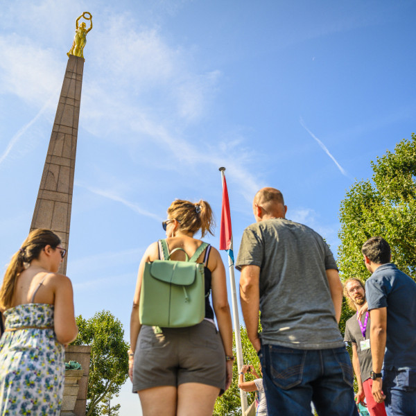 Group of visitors in front of the Gëlle Fra